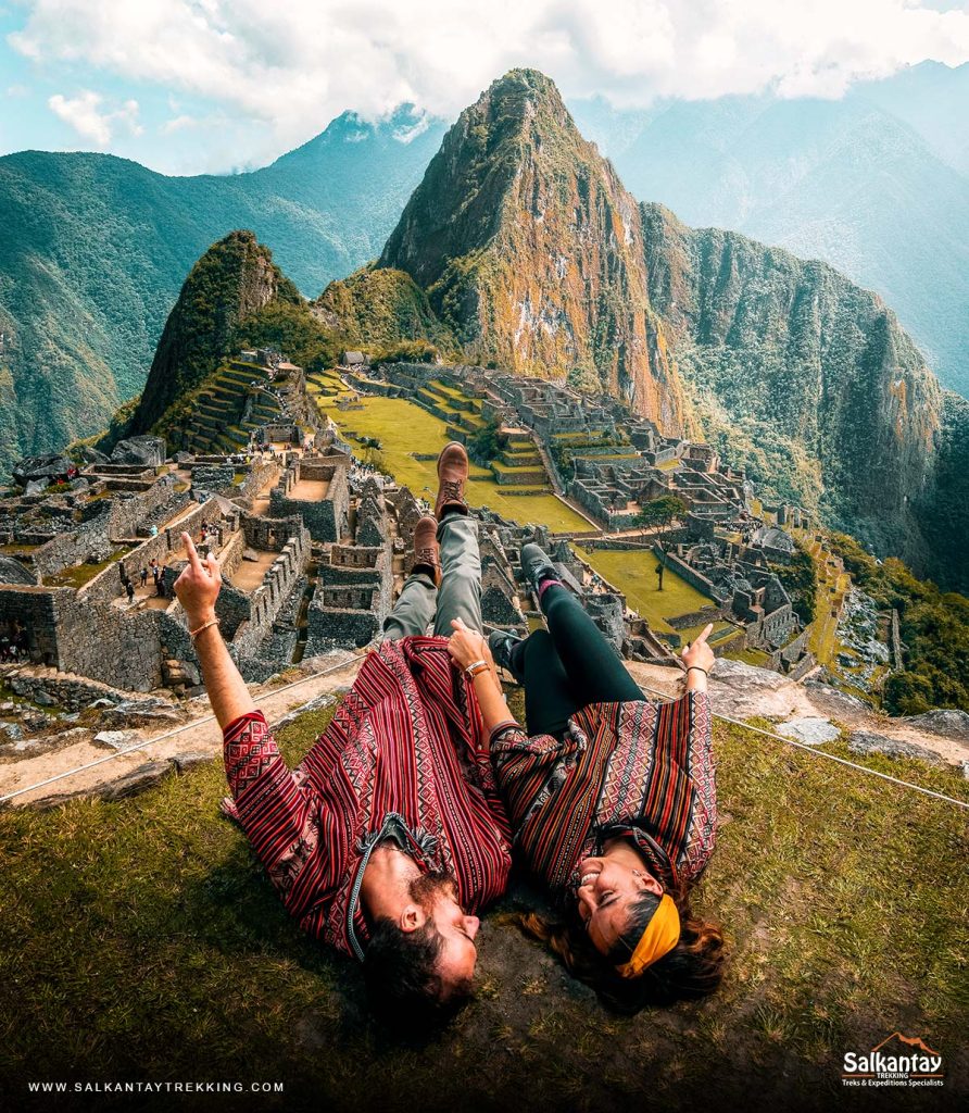 Pareja de turistas con ponchos andinos en Machu Picchu