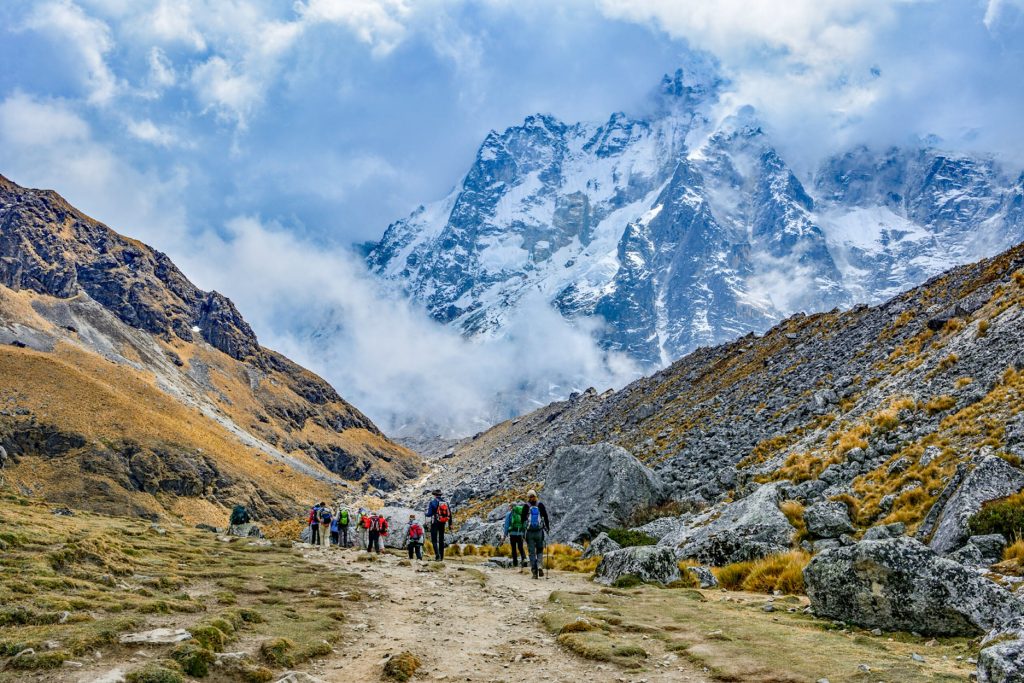 Grupo de turistas caminando hacia la montaña nevada de Salkantay