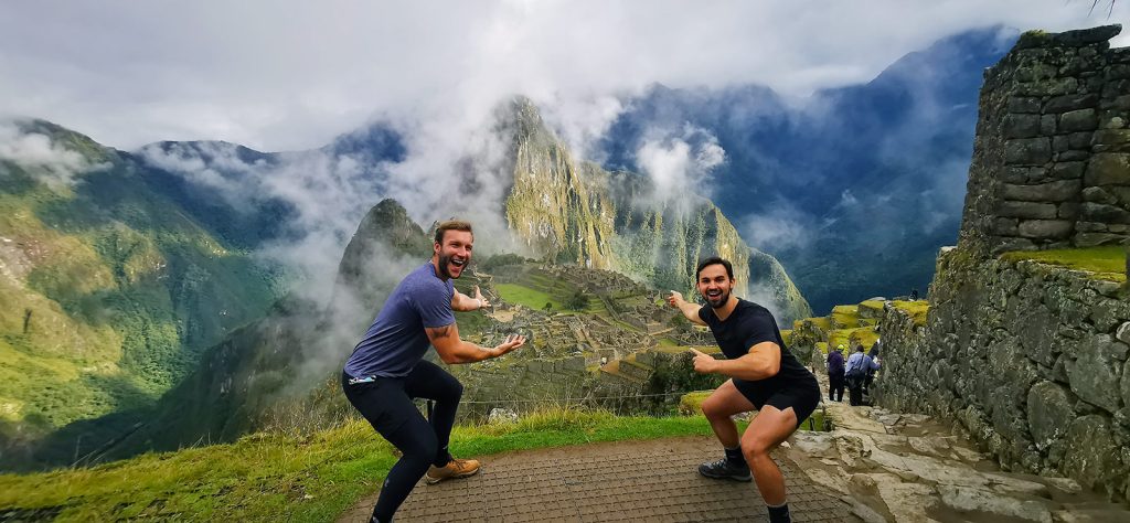 Dos turistas señalan la ciudad inca de Machu Picchu.