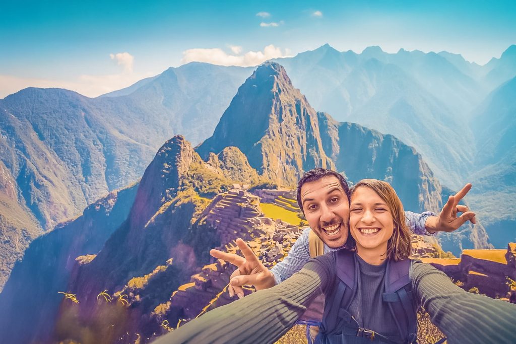 Una pareja de turistas felices en la ciudadela de Machu Picchu