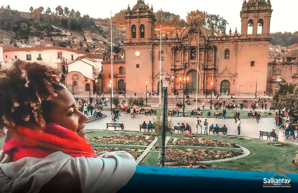 Una mujer tomando café en la plaza de Cusco