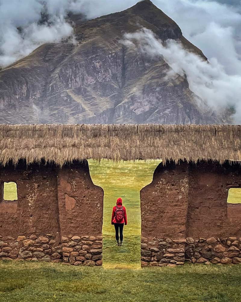 Mujer recorriendo el sitio arqueológico inca de Huchuy Qosqo