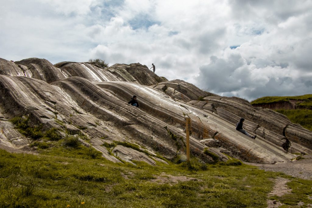 Personas en el Rodadero (Suchuna) en el sitio arqueológico de Sacsayhuamán