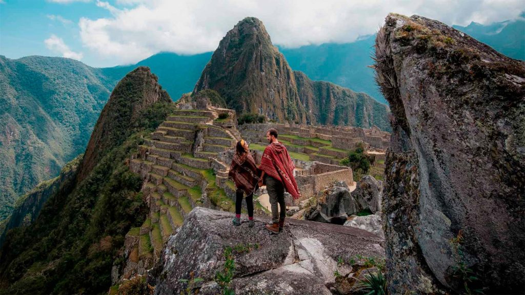 Retrato de pareja frenta a la majestuosa montaña Machu Picchu