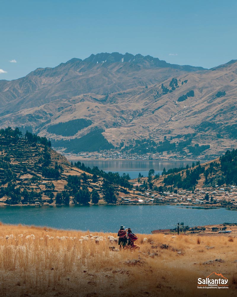 Dos personas andinas con el fondo de la laguna de Pomacanchi