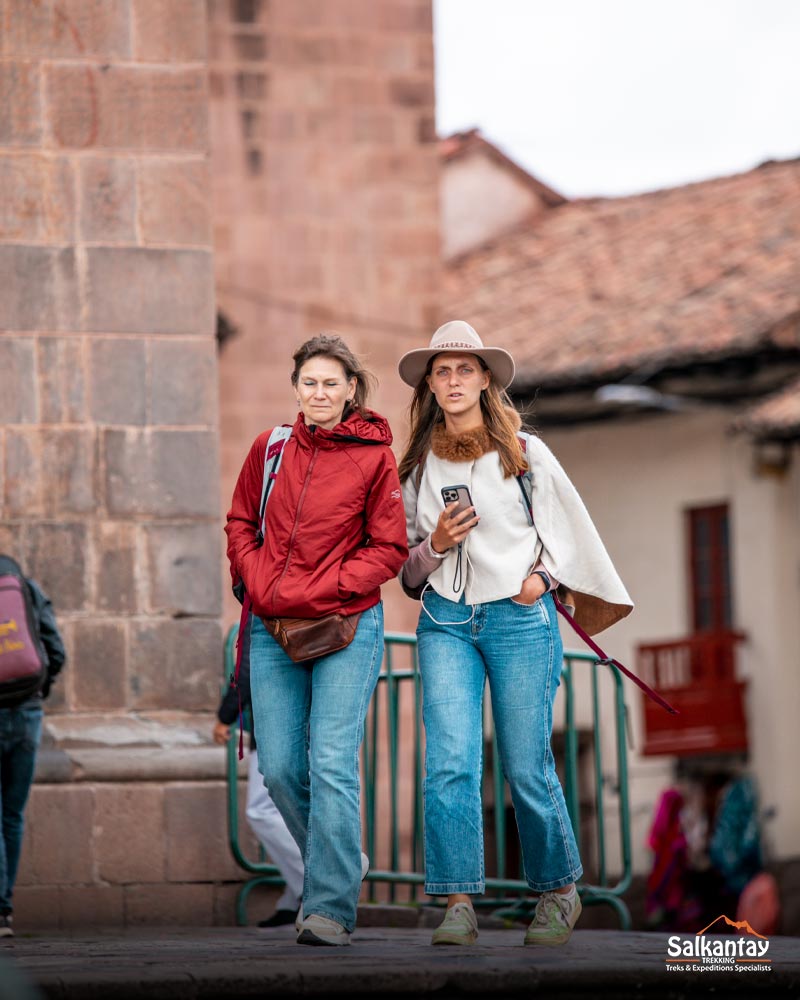 Gente paseando y disfrutando del día en la plaza principal de Cusco.