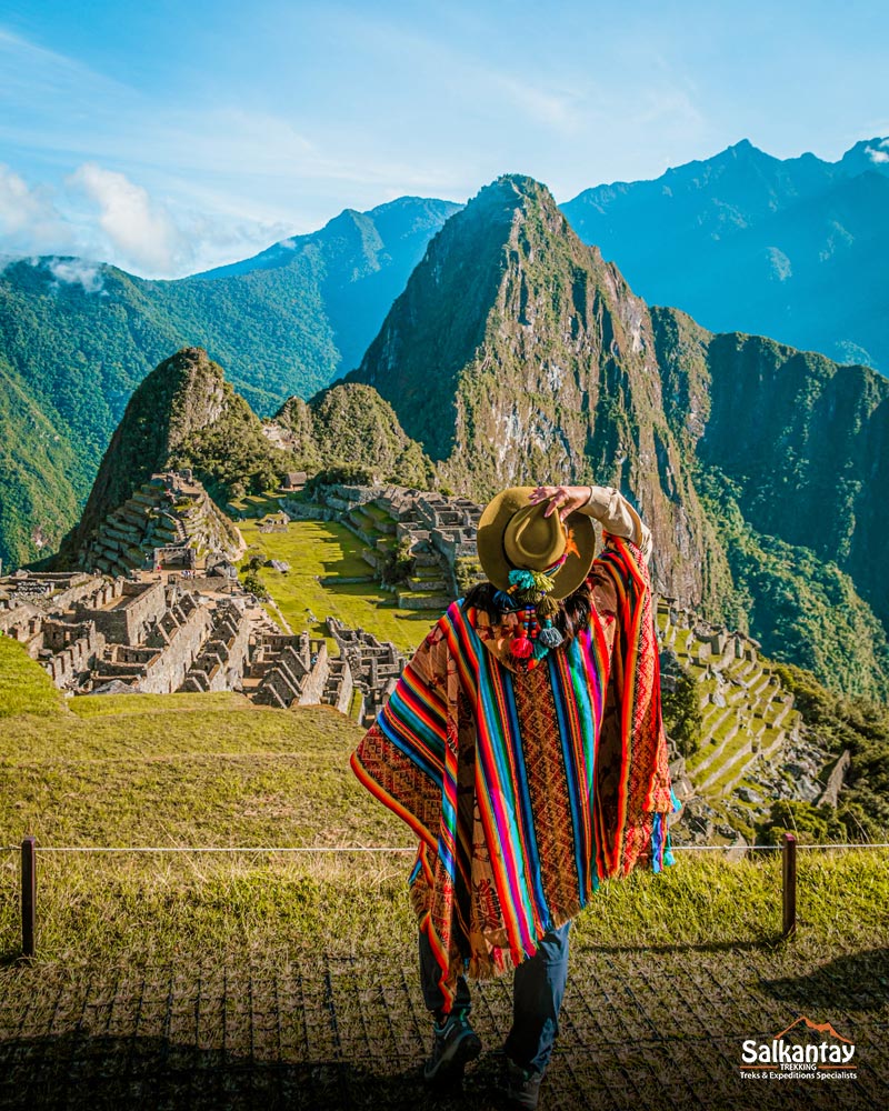 Turista con colorido poncho andino en Machu Picchu