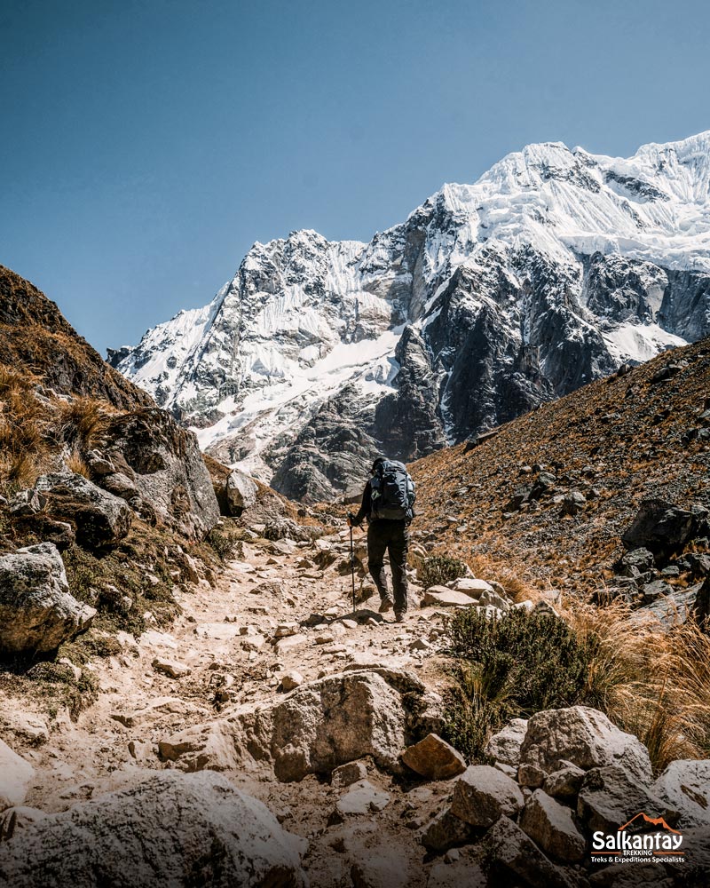 Turistas caminando hacia el paso Salkantay junto al inmensa montaña Salkantay.