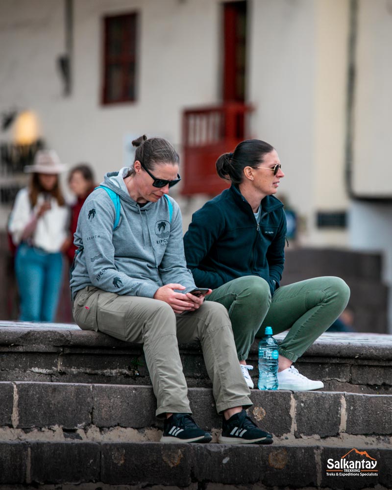 Dos turistas descansando en la plaza principal de Cuzco.