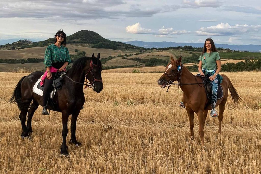 Dos turistas tomando un paseo a caballo en Cusco