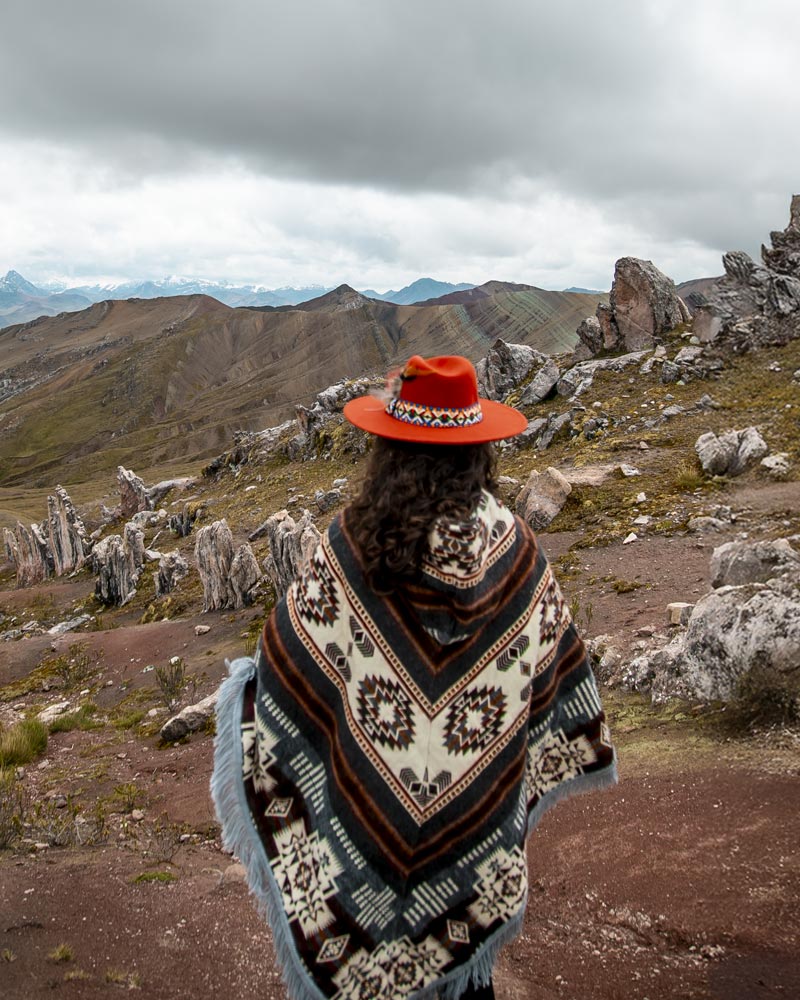 Turista con ropa andina en la montaña de colores de Palccoyo