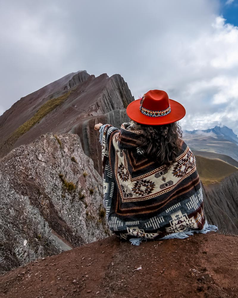 Turista con ropa andina en la montaña de colores de Pallay Punchu