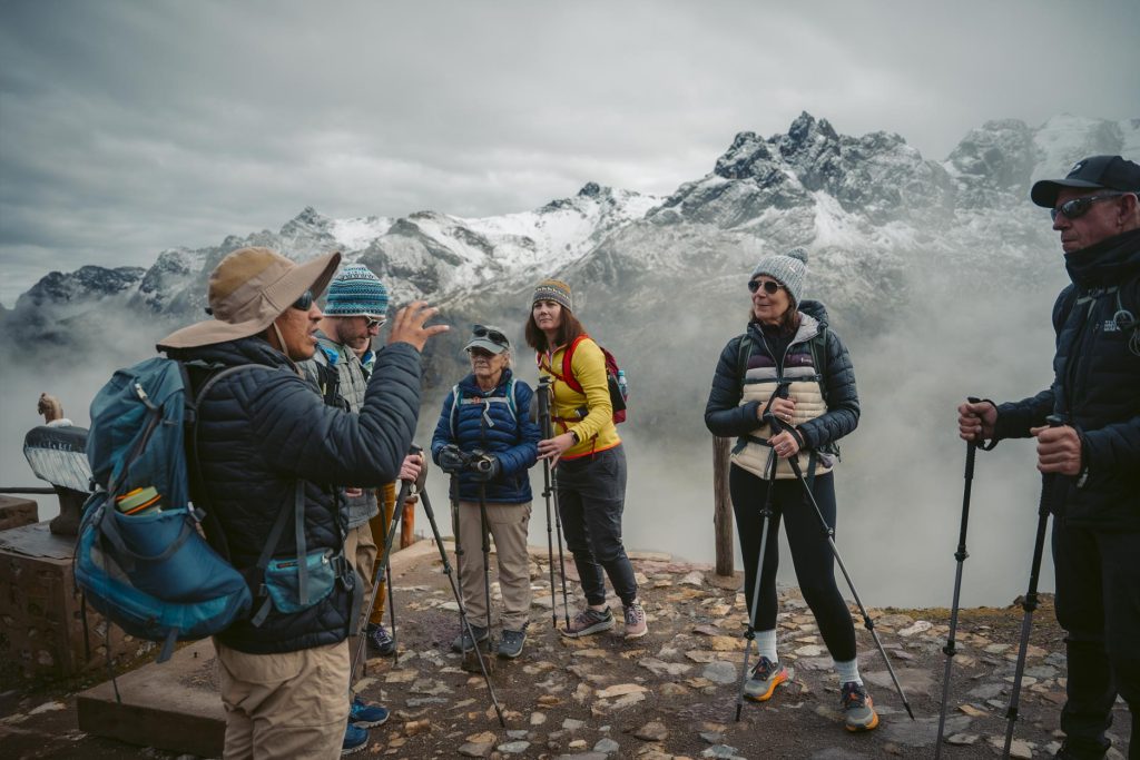 Grupo de turistas con bastones de trekking y su guia alistandose para empezar la caminata a la montaña de colores de Vinicunca