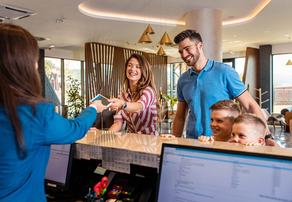 Una familia muy feliz en la recepción de un hotel