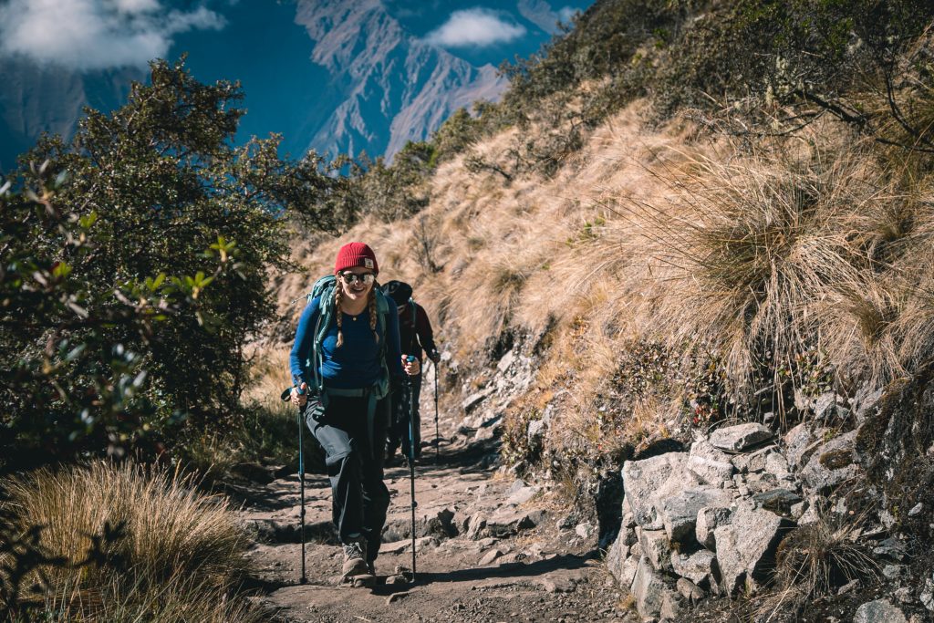 Mujer feliz caminando por el Camino Inca hacia Machu Picchu