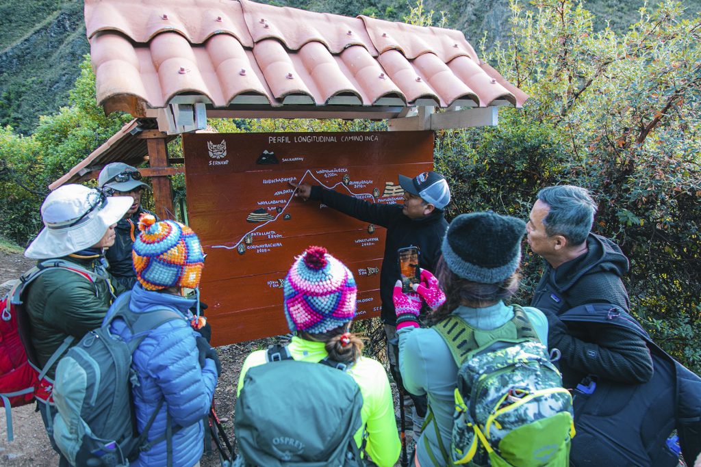 Guía explicando a un grupo de turistas en el Camino Inca