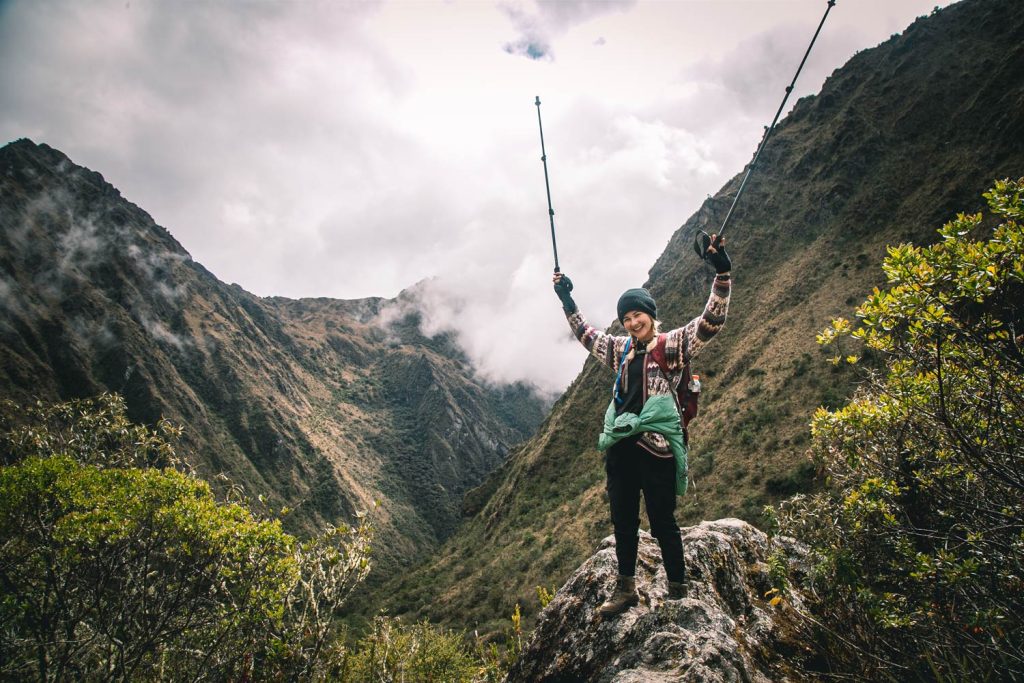 Mujer posando feliz en el camino inca