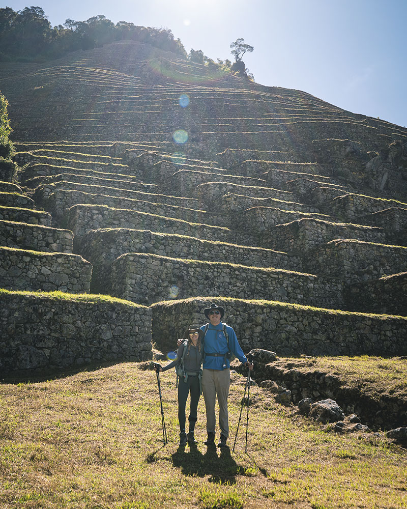 Turistas posando al pie de la andenería inca en Wiñay Wayna 