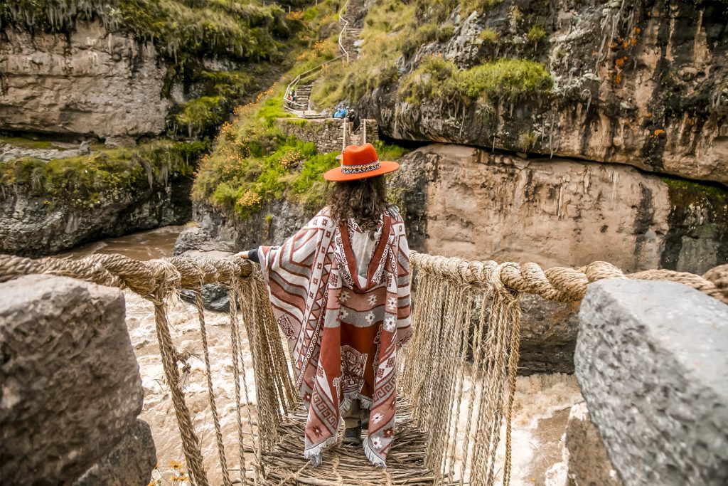 Turista con poncho andino en el Puente Q’eswachaka