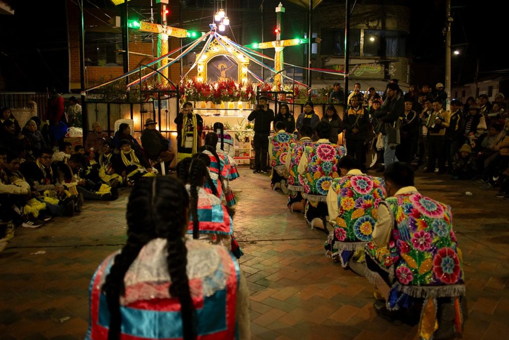 Bailarines arrodillados en Cruz Velacuy en Cusco