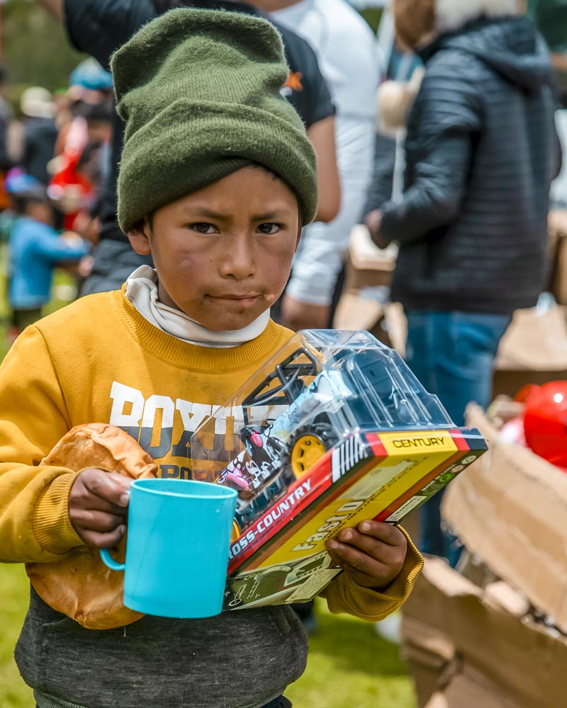 Niño con su juguete y taza de chocolate de Ausangate en la campaña navideña desarrollada por Salkantay Trekking