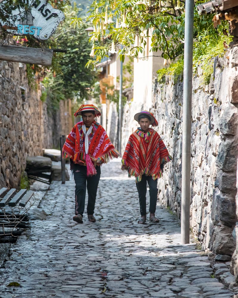 2 personas con ponchos andinos en el pueblo de Ollantaytambo
