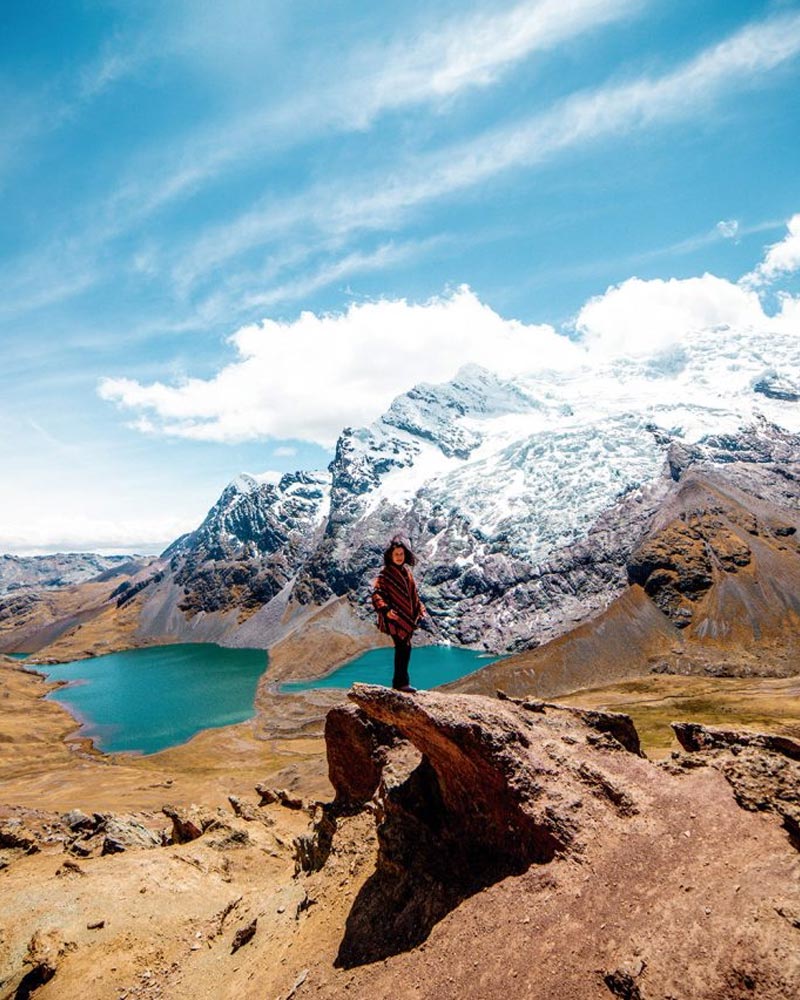 Turista con poncho andino con el fondo de la Montaña Ausangate
