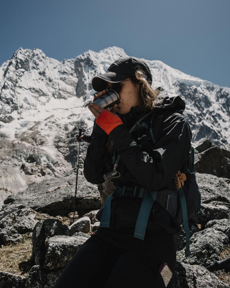 Turista tomando té de coca en el paso de Salkantay.