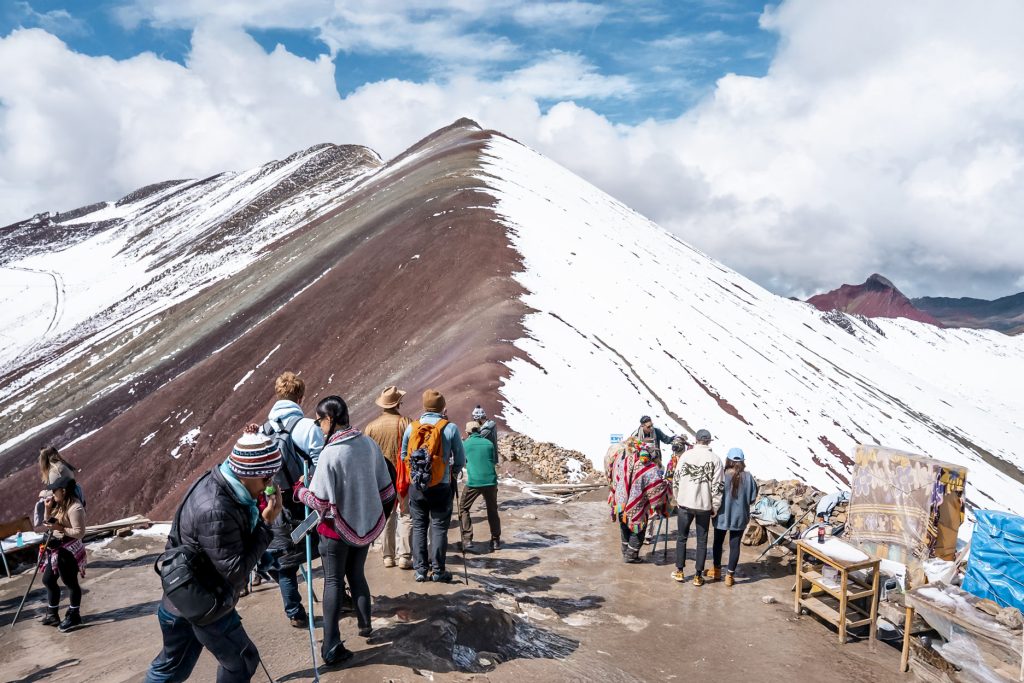 Foto panorámica de grupos de turistas en la Montaña Arcoíris de Vinicunca.