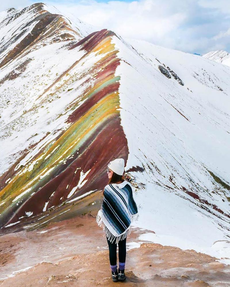 Turista en la Montaña de colores cubierta por nieve