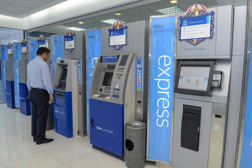 Hombre retirando dinero del cajero automático azul