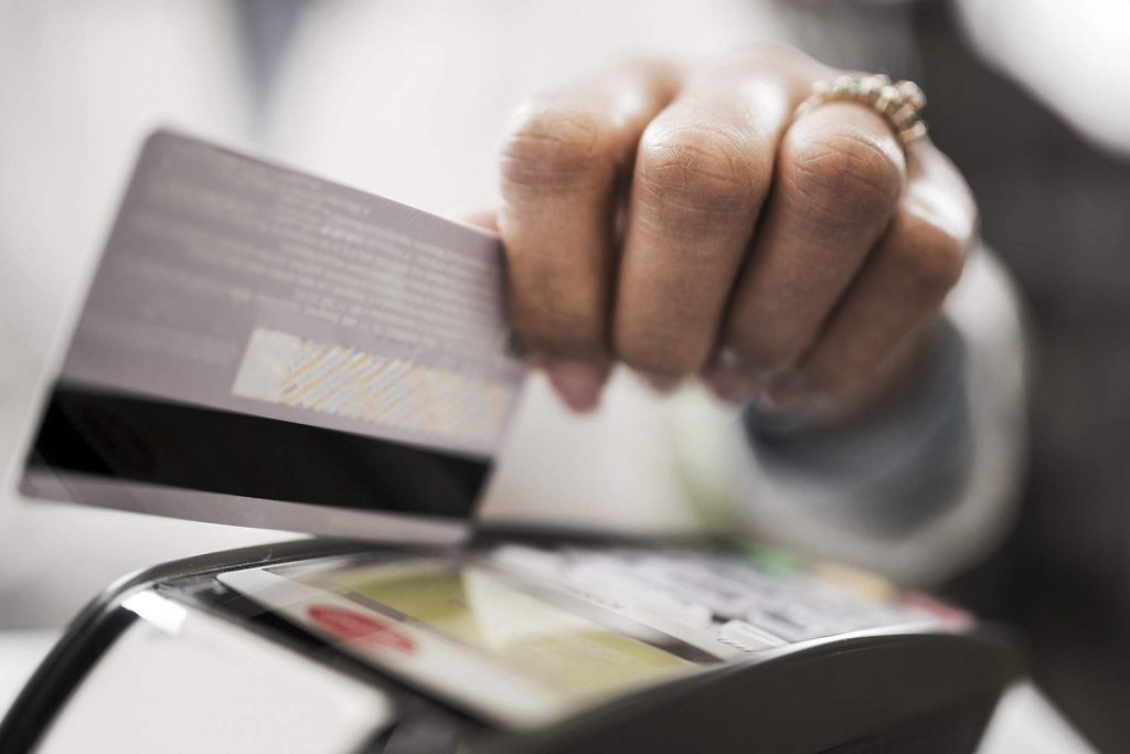 Persona usando POS con su tarjeta de crédito