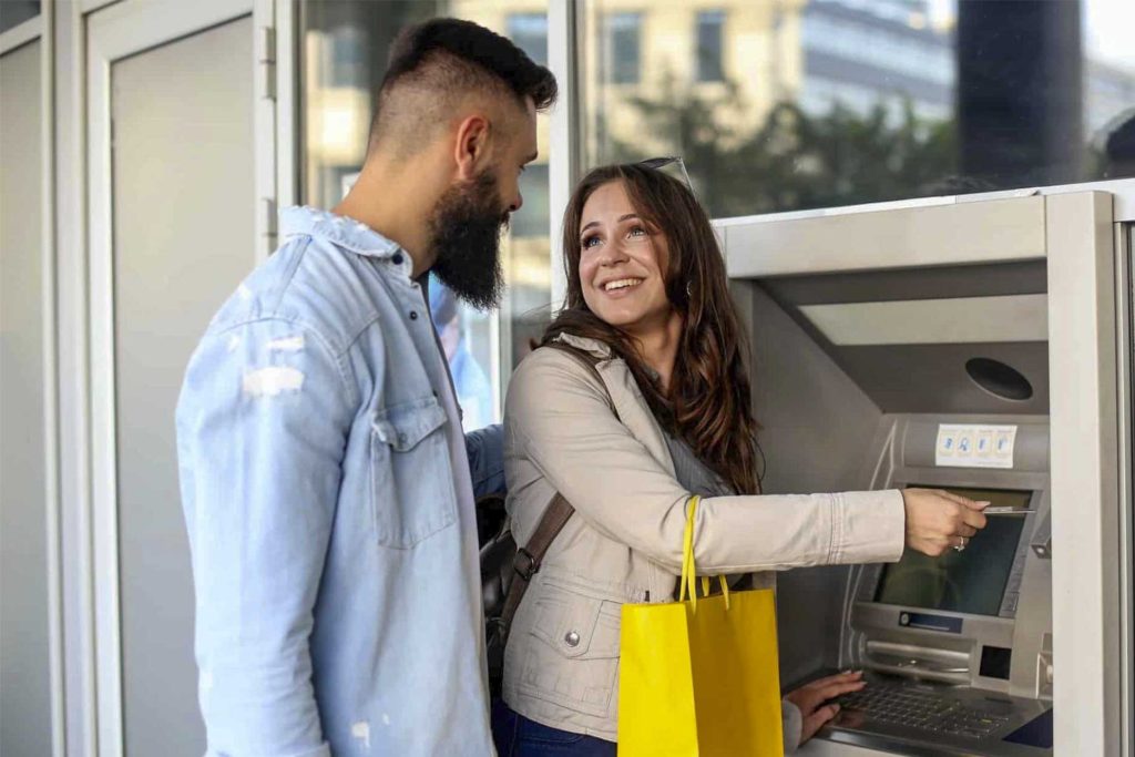 Pareja usando cajero automático