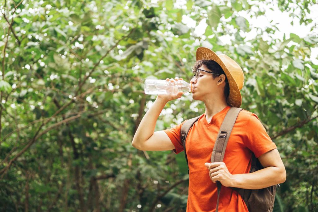 Turista tomando agua en una caminata