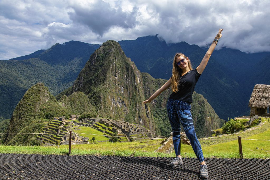 Foto clásica de Machu Picchu con una turista posando feliz