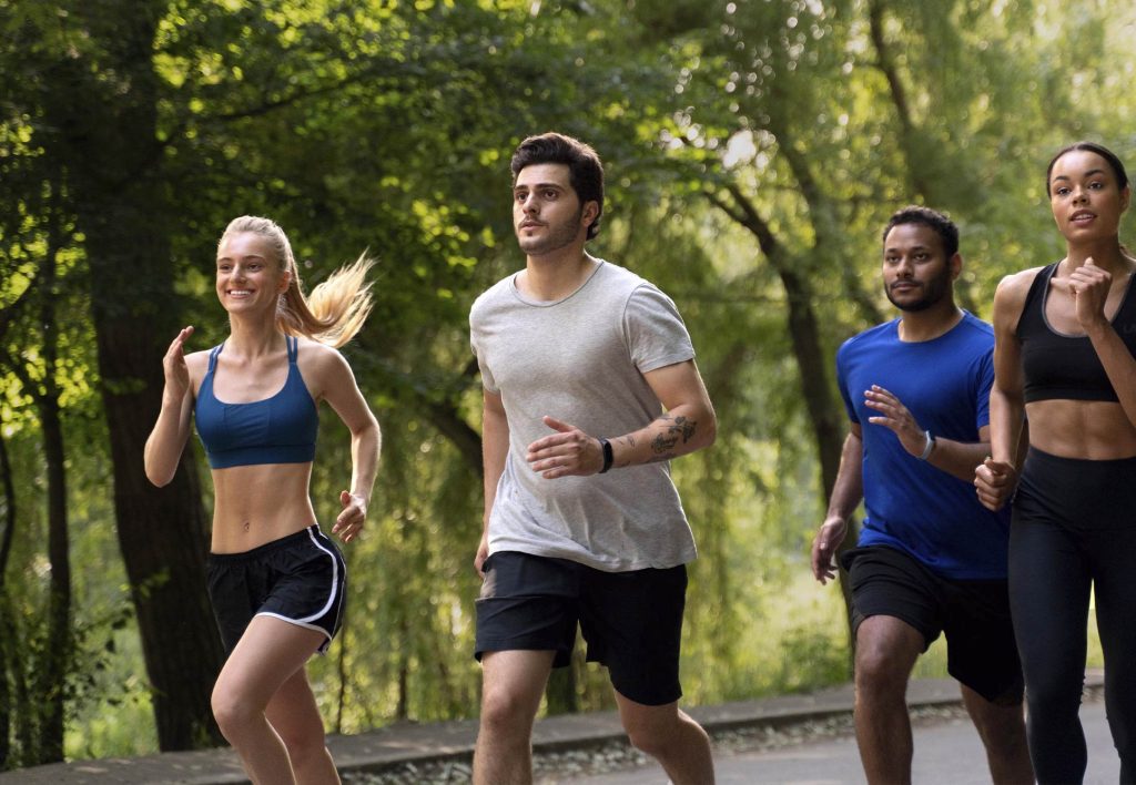 Grupo de personas trotando en un parque como entrenamiento para trekking