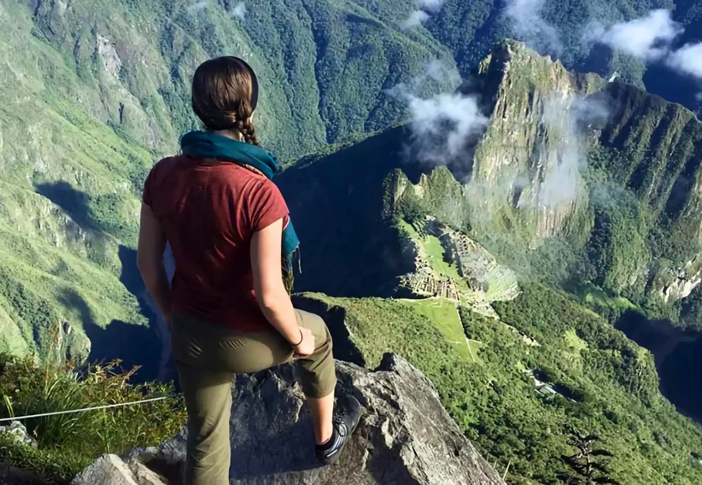 Mujer con vista panorámica desde la cima de la montaña Machu Picchu, con el boleto del circuito 1