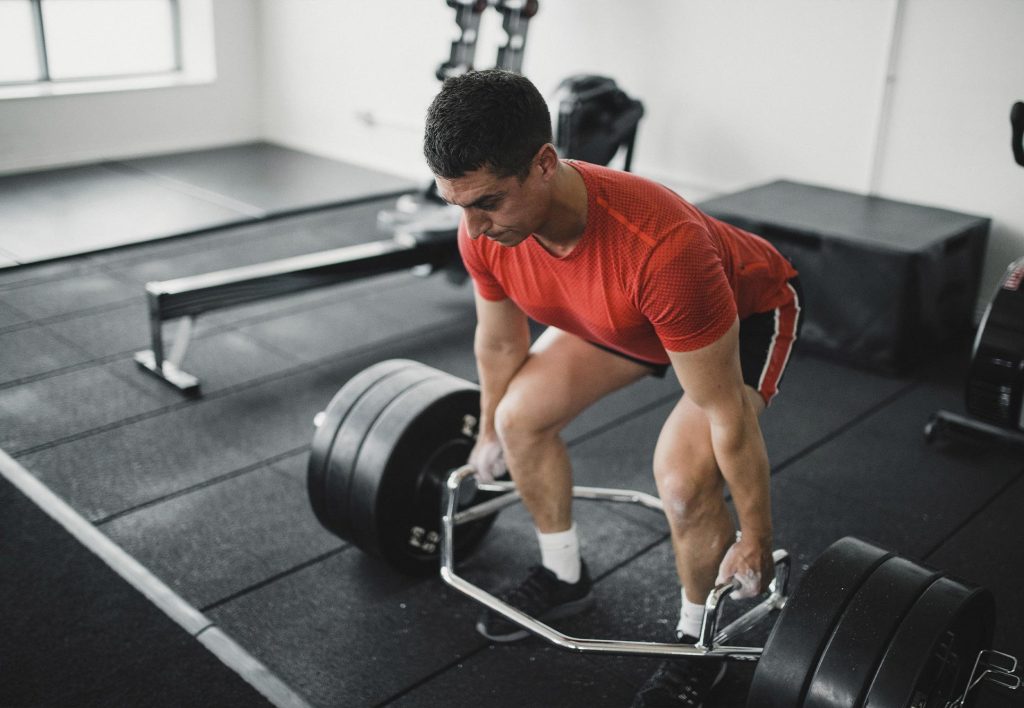 Persona entrenando con ejercicios de peso muerto en el gimnasio