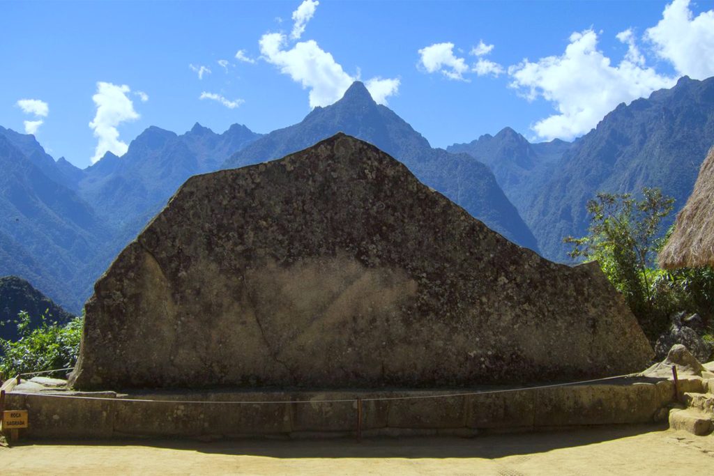 Fotografia de la Roca Sagrada en Machu Picchu, alineada con la montaña que se encuentra tras ella, simbolizando el Yanantin en la cultura andina