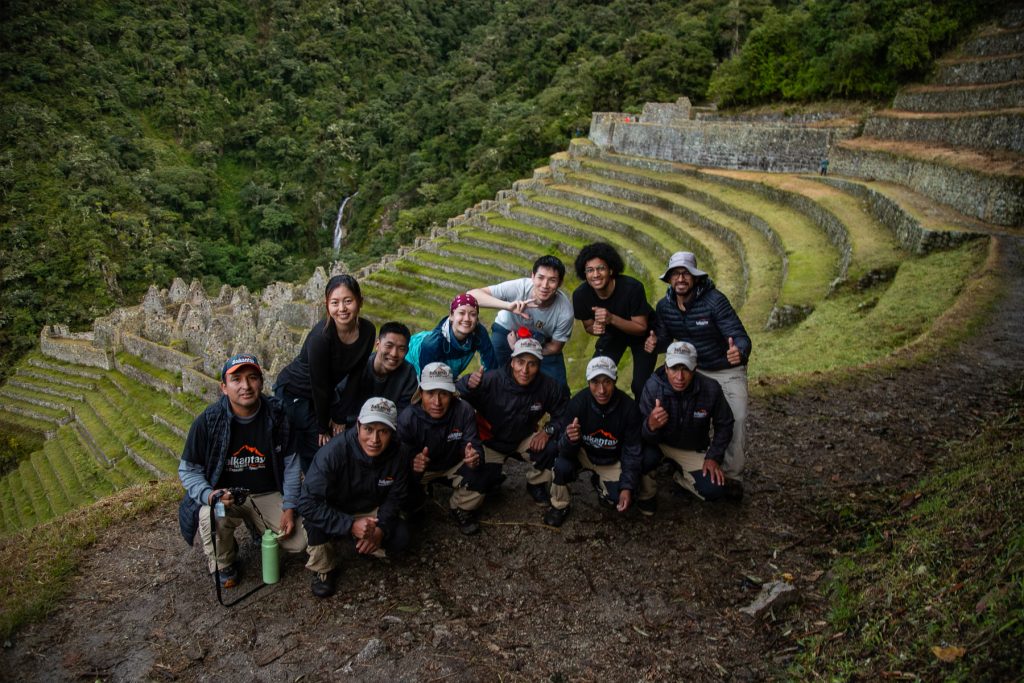 Grupo de turistas y equipo de excursionistas en el sitio arqueológico de Wiñay Wayna en el Camino Inca.