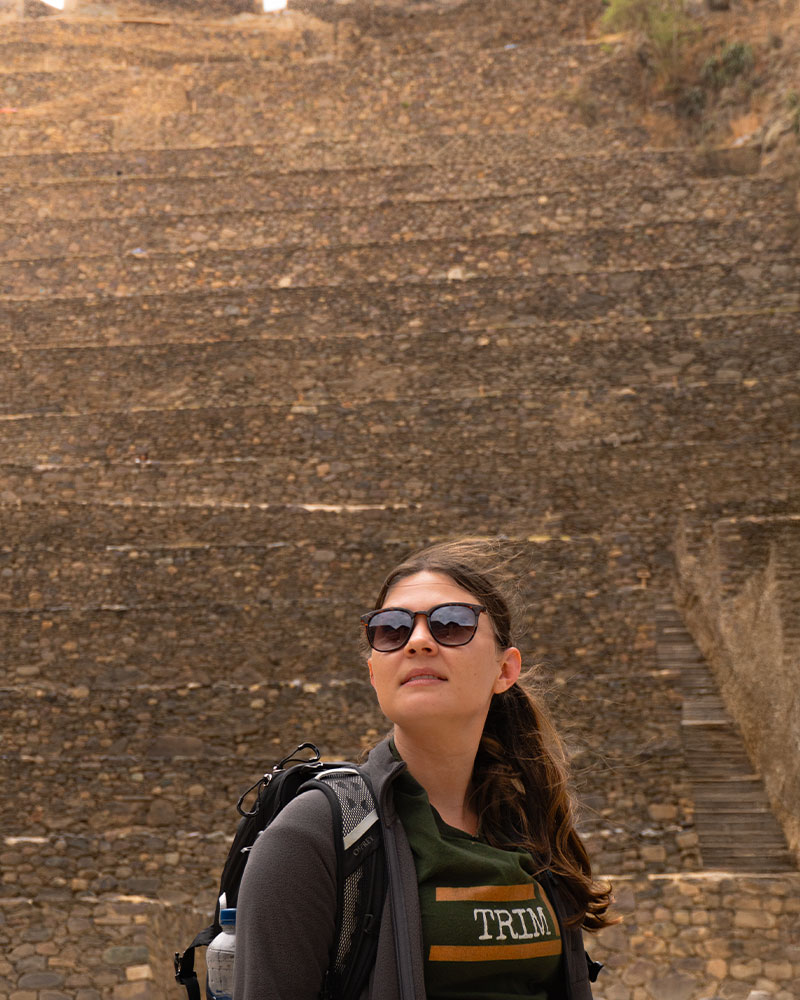 Turista en el ingreso del sitio arqueológico de Ollantaytambo, al pie de la andeneria 
