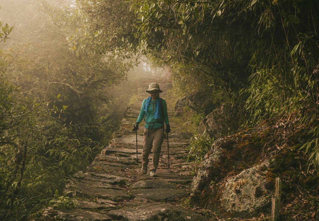Turista caminando en el Camino Inca durante el atardecer