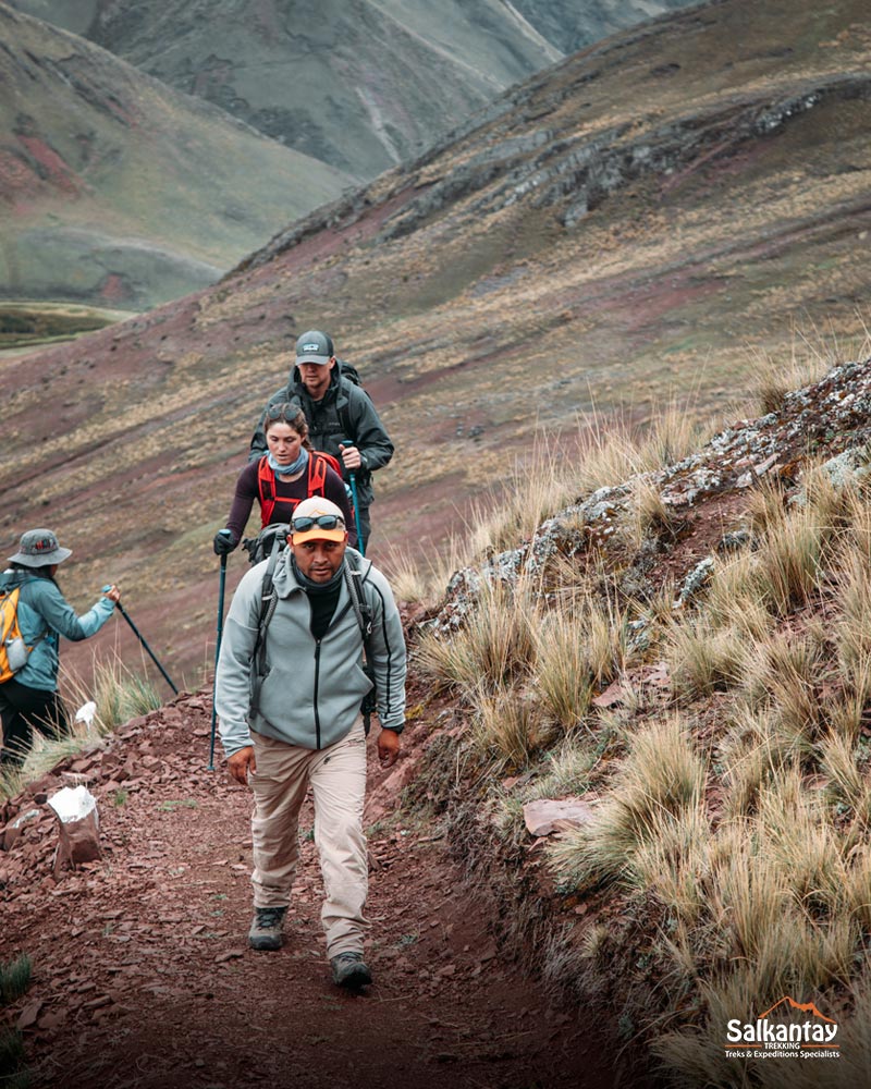 Turistas y su guía caminando hacia la colorida montaña de Pallay Punchu.