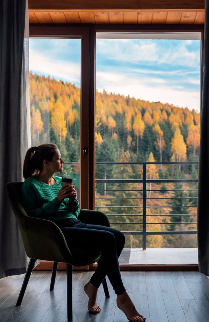 Un viajero se relaja en la cama de un hotel mientras se aclimata a la altitud de la montaña.