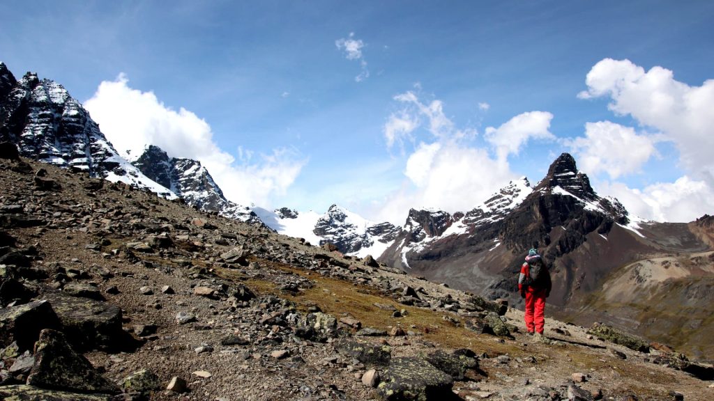 Una impresionante vista del pico Condoriri, cubierto de nieve, reflejándose en una laguna de alta montaña durante la ruta de senderismo.