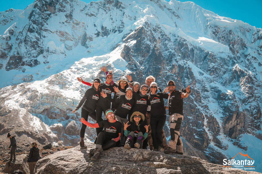 Grupo de turistas de pie sobre una roca en el paso de Salkantay