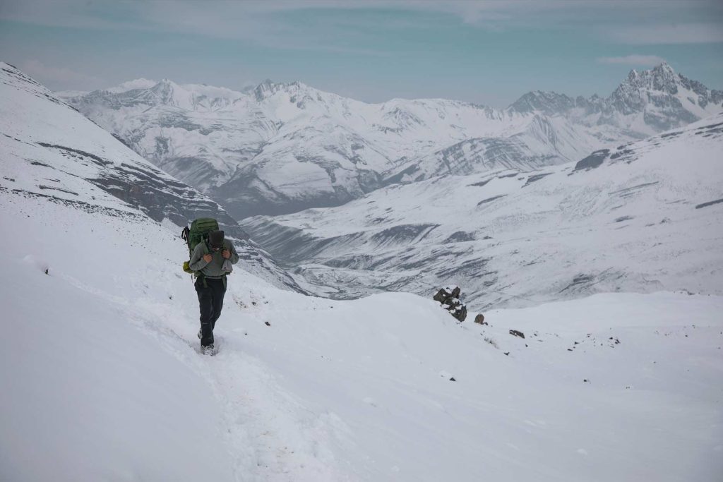 Turista con equipo de senderismo explorando las montañas nevadas de Ausangate