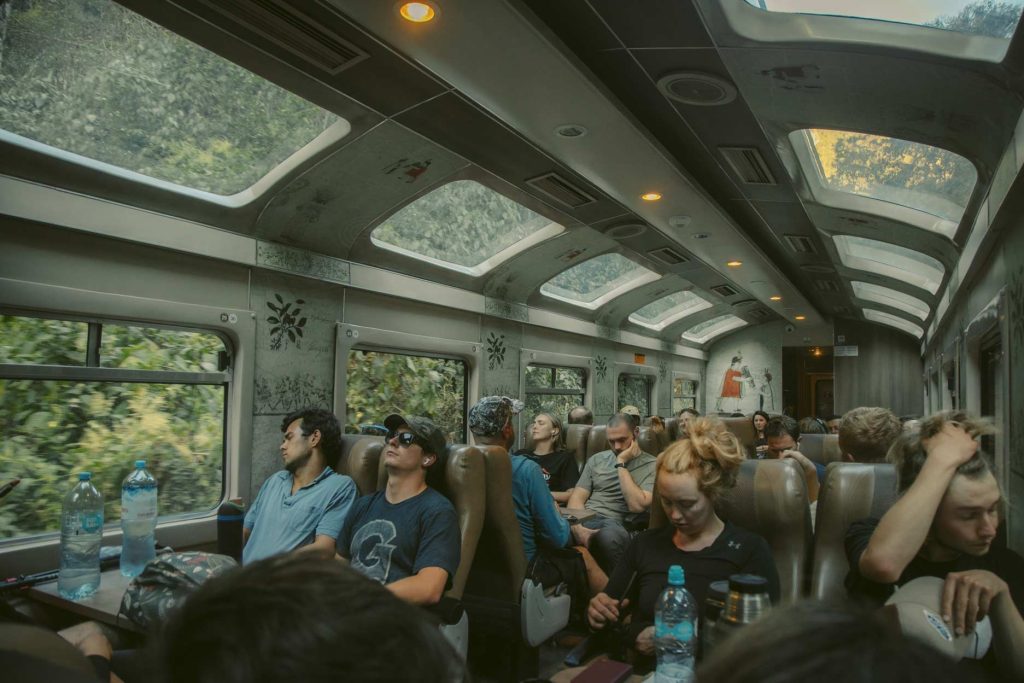 Turistas sentados en un tren a Machu Picchu