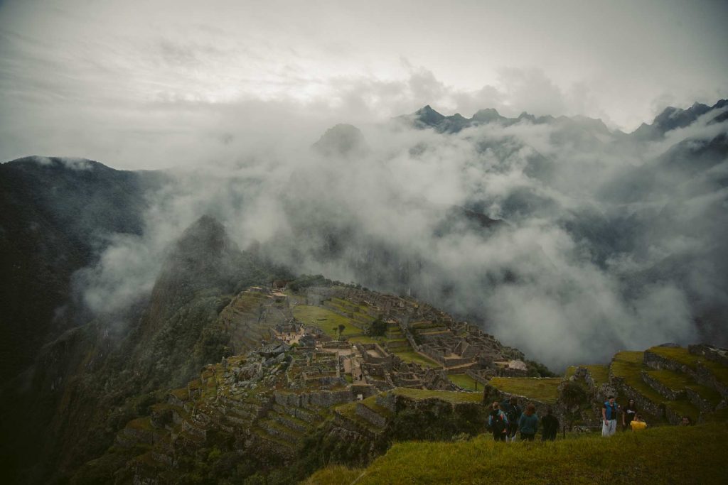 La ciudadela de Machu Picchu parcialmente cubierta de niebla.