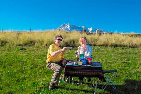 Dos turistas que disfrutan de una comida al pie de la nieve